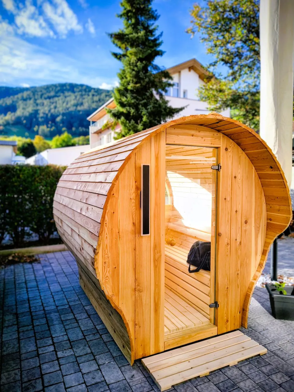 DiSauna Referenzprojekt – Eck-Gartensauna mit Glasfront auf Terrasse