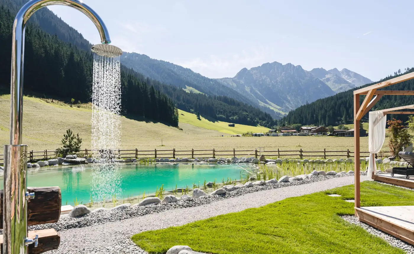 Außendusche und Naturpool mit Blick auf die Berge – Outdoor Wellness